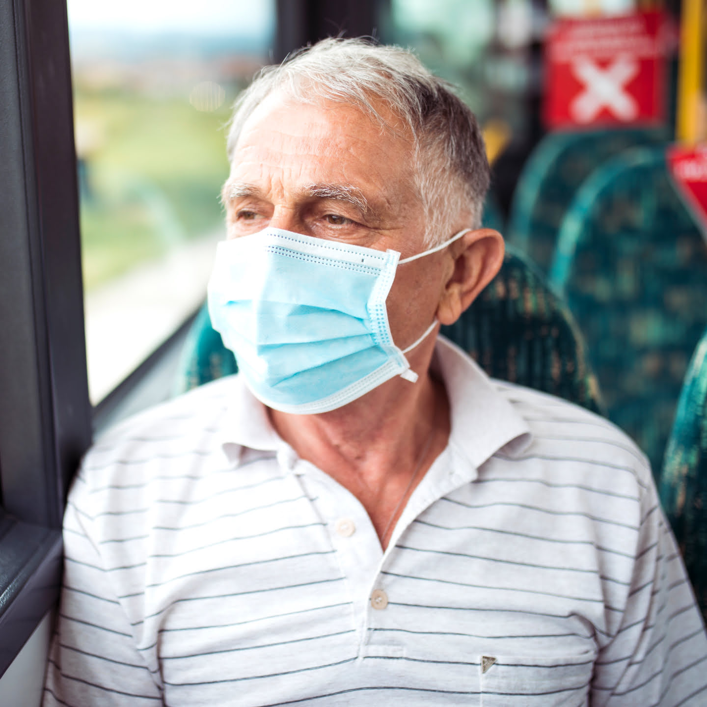A man wearing a mask on a bus or train
