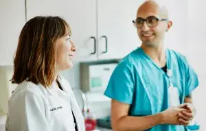 A doctor talking with another care team member