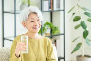 Senior holding up a glass of water