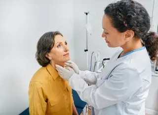 Medical professional examining patient's neck
