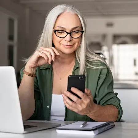 senior woman with phone and laptop