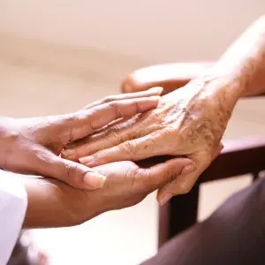 Younger person holding older person’s hand