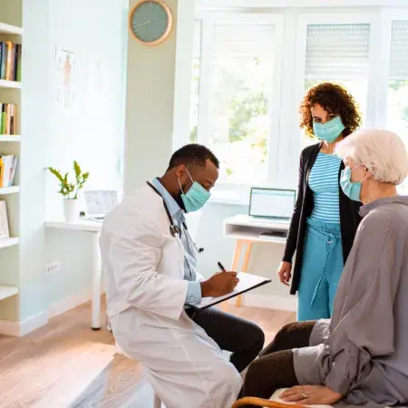 A doctor talking with an older woman and a family member
